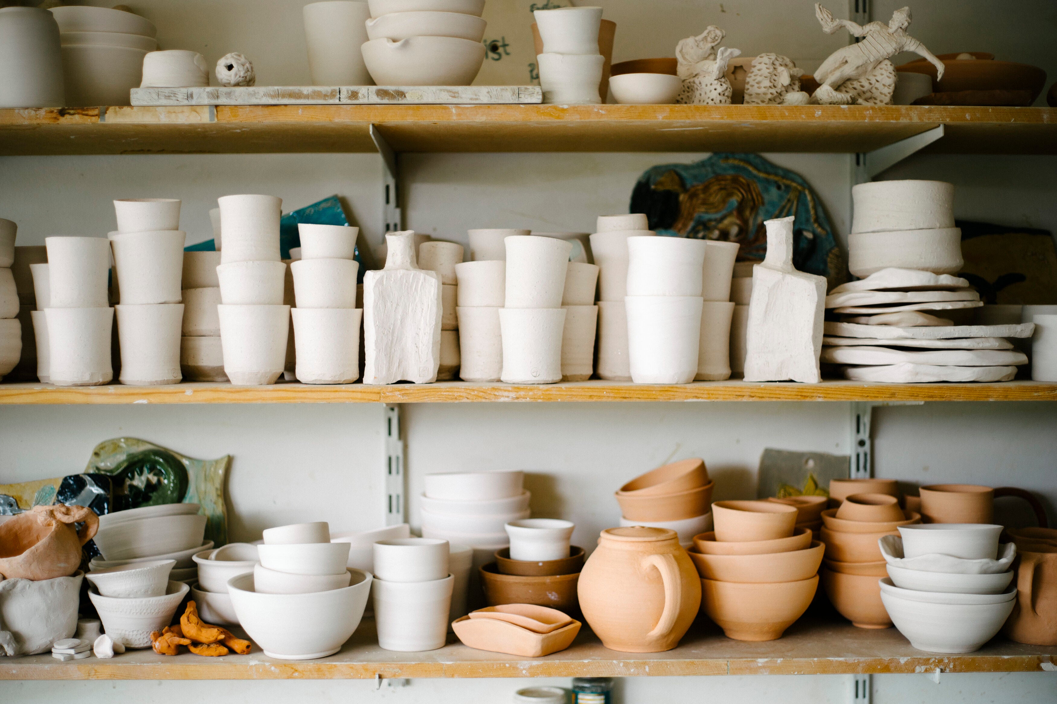 Beautiful display of ceramic ware stacked on shelves by The Potters Project.